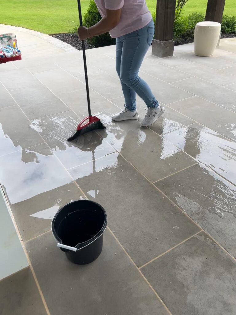 A person sweeping water on a tiled floor, representing the thoroughness of special event cleaning in Georgia.